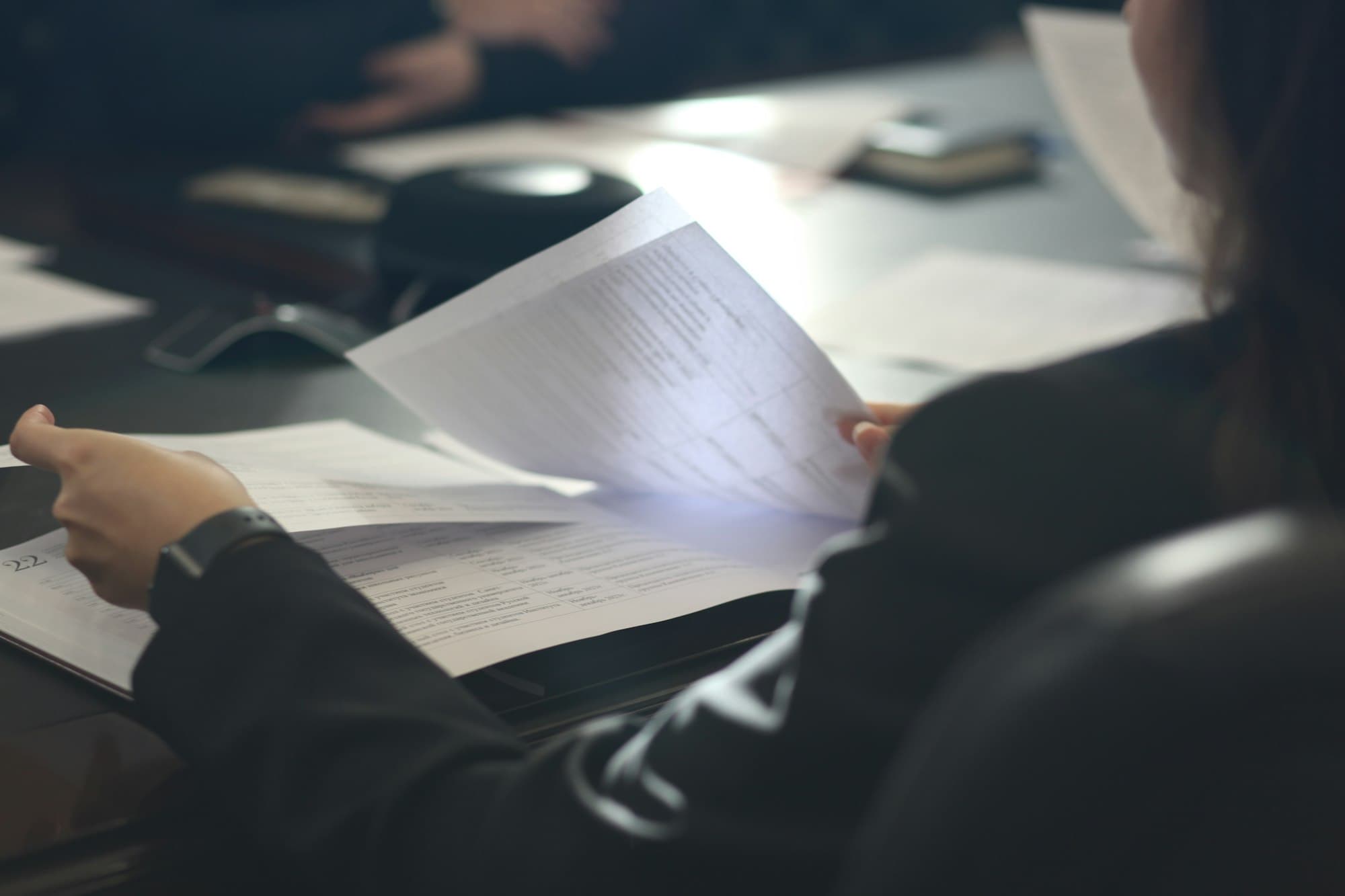 A woman reading business documents at her desk